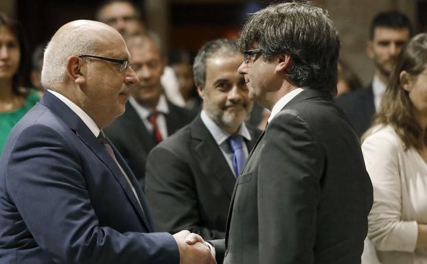 Puigdemont saluda al exconsejero destituido Jordi Baiget poco antes de la toma de posesión de su sustituto./ANDREU DALMAU / EFE