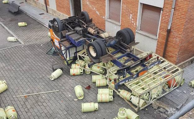 El camión, volcado, con todas las bombonas por el suelo