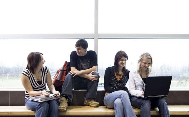 Estudiantes universitarios hablan en la escuala.