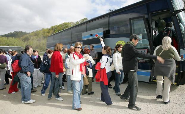 Turistas, cogiendo el autobús de acceso a los Lagos de Covadonga. /NEL ACEBAL