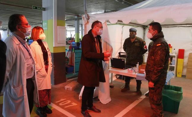 El consejero de Salud habla con los militares que atienden uno de los puntos de vacunación del HUCA./JOSE VALLINA