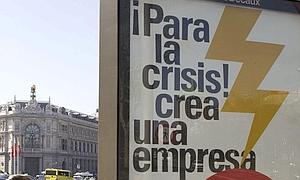 Un cartel publicitario con referencia a la crisis de la economía española, junto a la sede del Banco de España, en Madrid. / Ap/