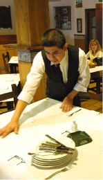 HOSTELERÍA. Un camarero ecuatoriano pone la mesa en un restaurante de Gijón. / E. C./