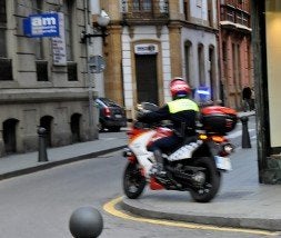 Un policía circula en moto por la acera en las inmediaciones del centro comercial San Agustín. / JAVIER BAULUZ/