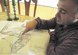 Agustín García Fernández señala en un plano las zonas del entorno de Zeluán afectadas por la ley de Costas. :: MARIETA/