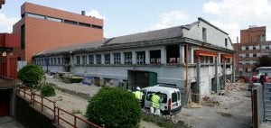 Trabajadores en el exterior de las naves de la antigua fábrica de Confecciones Camino, donde se construye la Factoría Cultural :: RAFA GONZÁLEZ/