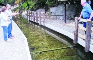 El alcalde taramundés, Eduardo Lastra (a la derecha), junto al canal de agua recuperado. ::
E. C./
