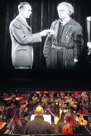 La orquesta, en primer término, con la película de fondo. ::
M. ROJAS/