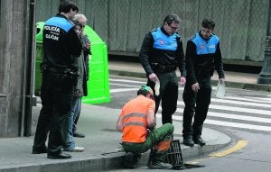 Un operario rescata el cuchillo de la alcantarilla en presencia de agentes de la Policía Local. ::
LUIS SEVILLA/