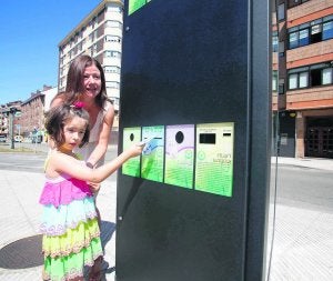 Una niña deposita un cedé en el mini punto limpio de El Entrego. ::
ROMÁN/