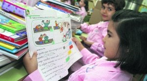 Dos niños, en su colegio, con el material escolar. :: E. C./