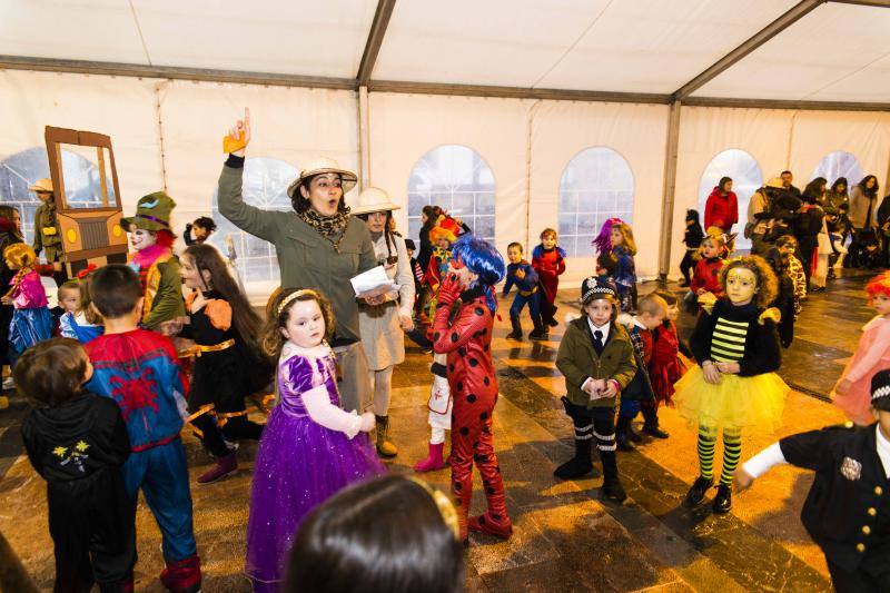 Los niños de Cangas de Onís se refugian de la lluvia bajo sus disfraces
