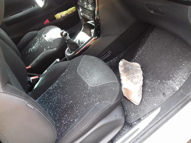 Herida leve pese a que una piedra de doce kilos atravesó la luna de su coche