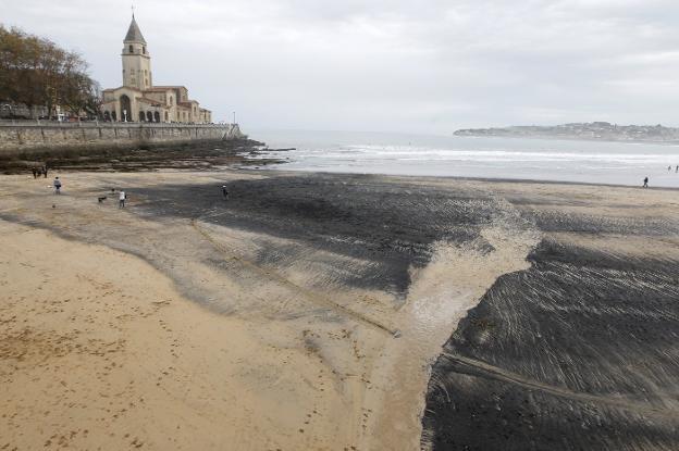 Los científicos vinculan el carbón que llega a la playa con los graneles que mueve El Musel
