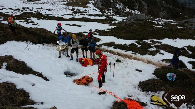 Rescatadores ante la sima cabraliega por donde cayó en abril de 2018 un montañero vasco. /  SEPA