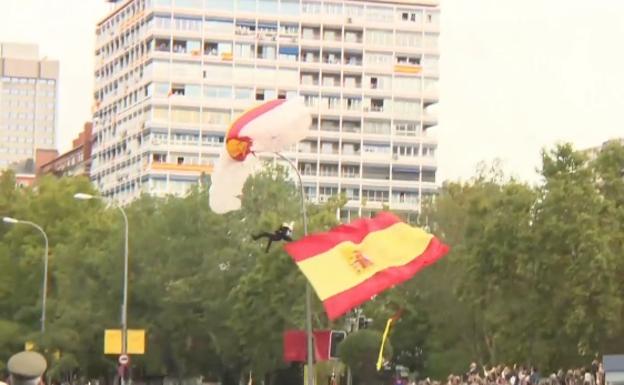 El paracaidista que portaba la bandera se queda enganchado en una farola
