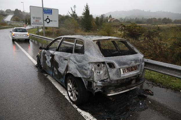 Coche calcinado en el ramal de salida a Quintes de la autovía A-8