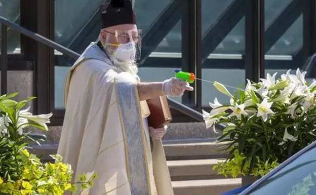 Un cura de Detroit bendice a los fieles con una pistola de agua infantil para mantener la distancia social