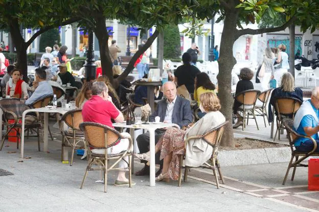 Varias personas, en una terraza en el gijonés paseo de Begoña. / ARNALDO GARCÍA