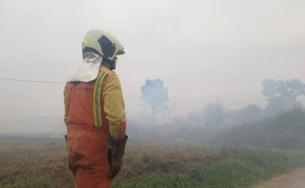 Los bomberos intentan sofocar un incendio forestal en La Belga, en Siero