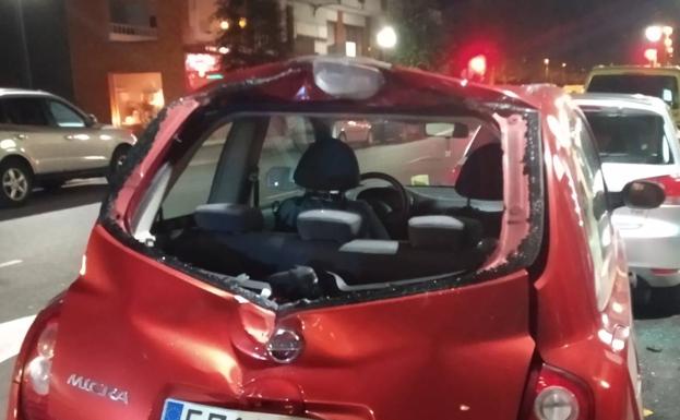 Un contenedor de reciclaje destroza el techo de un vehículo en Gijón