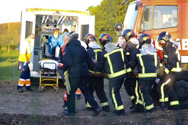 Rescatan a un hombre que quedó atrapado bajo una excavadora en una finca en Somió