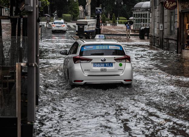 Veinte minutos de tromba de agua inundan el centro de la región y causan destrozos en Oviedo