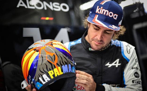 El piloto asturiano Fernando Alonso muestra un casco dedicado a La Palma