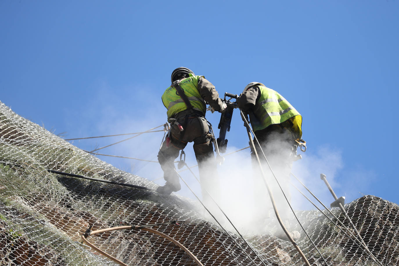 Los operarios fijan los bulones y las redes de contención en la AS-15