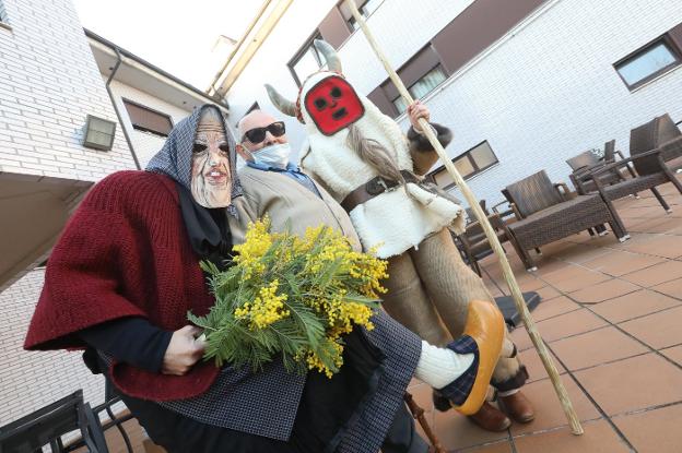 Un enmascarado con cuernos y pieles de oveja busca sitio en el Antroxu de Avilés