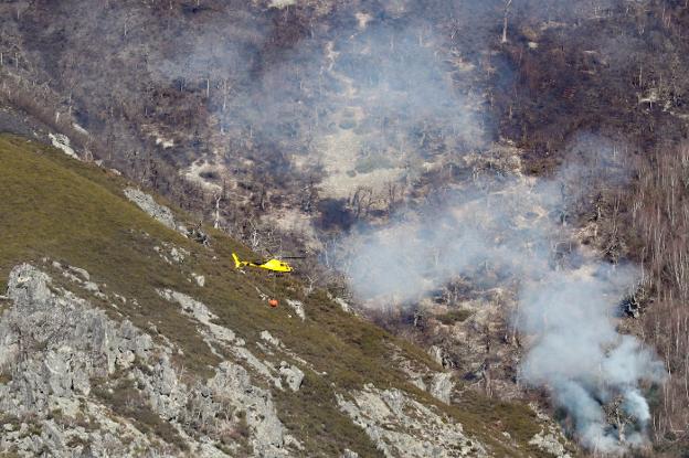 Cinco helicópteros impiden que el gran incendio de Ibias entre en Muniellos