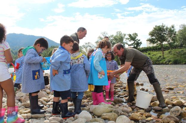 Los escolares de Parres inician la campaña de repoblación con cinco mil alevines