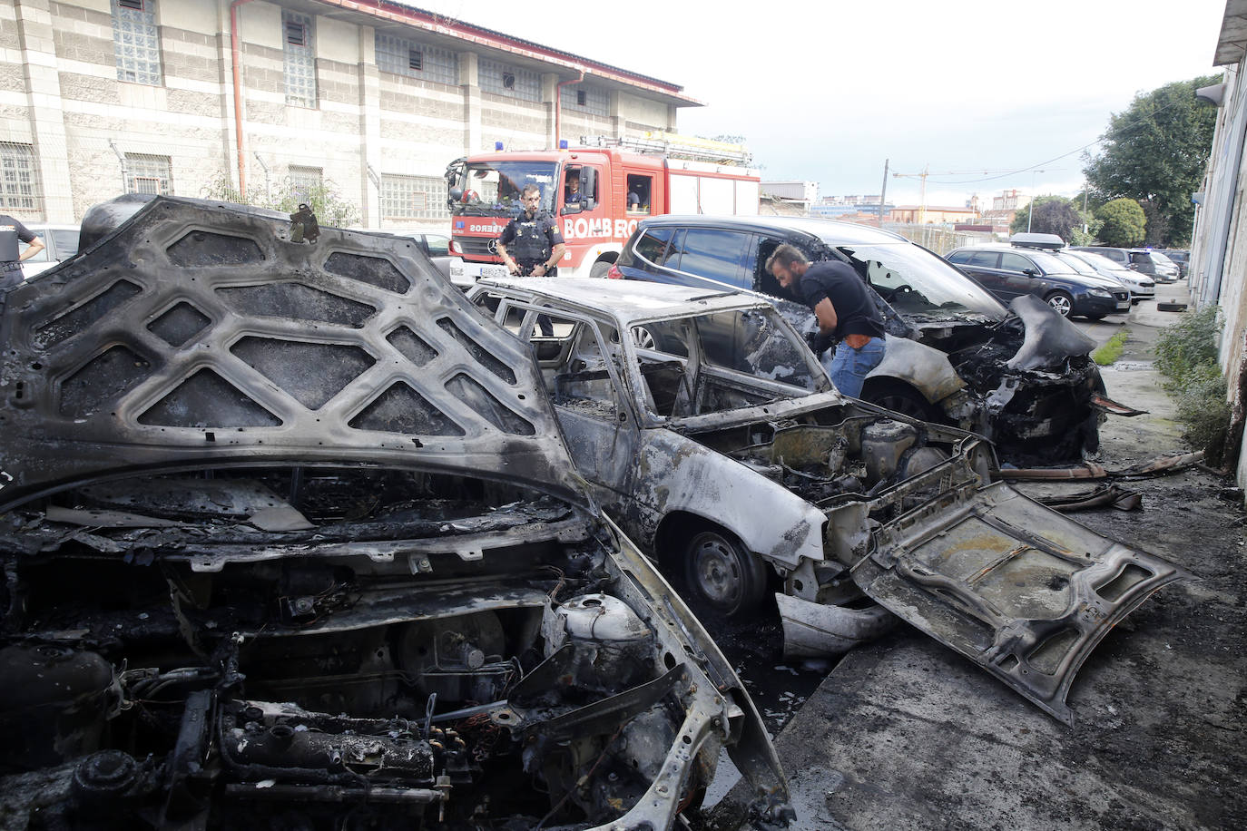 Arden cuatro coches aparcados junto al 'tallerón', en Gijón