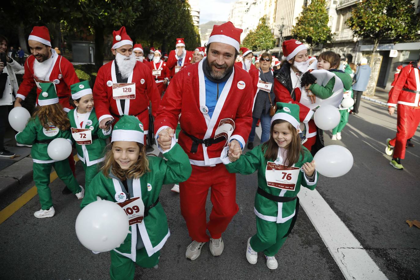 Marea roja de Papás Noel por las calles de Oviedo