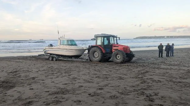 Un barco de recreo varado en Salinas acaba remolcado por un tractor en la playa