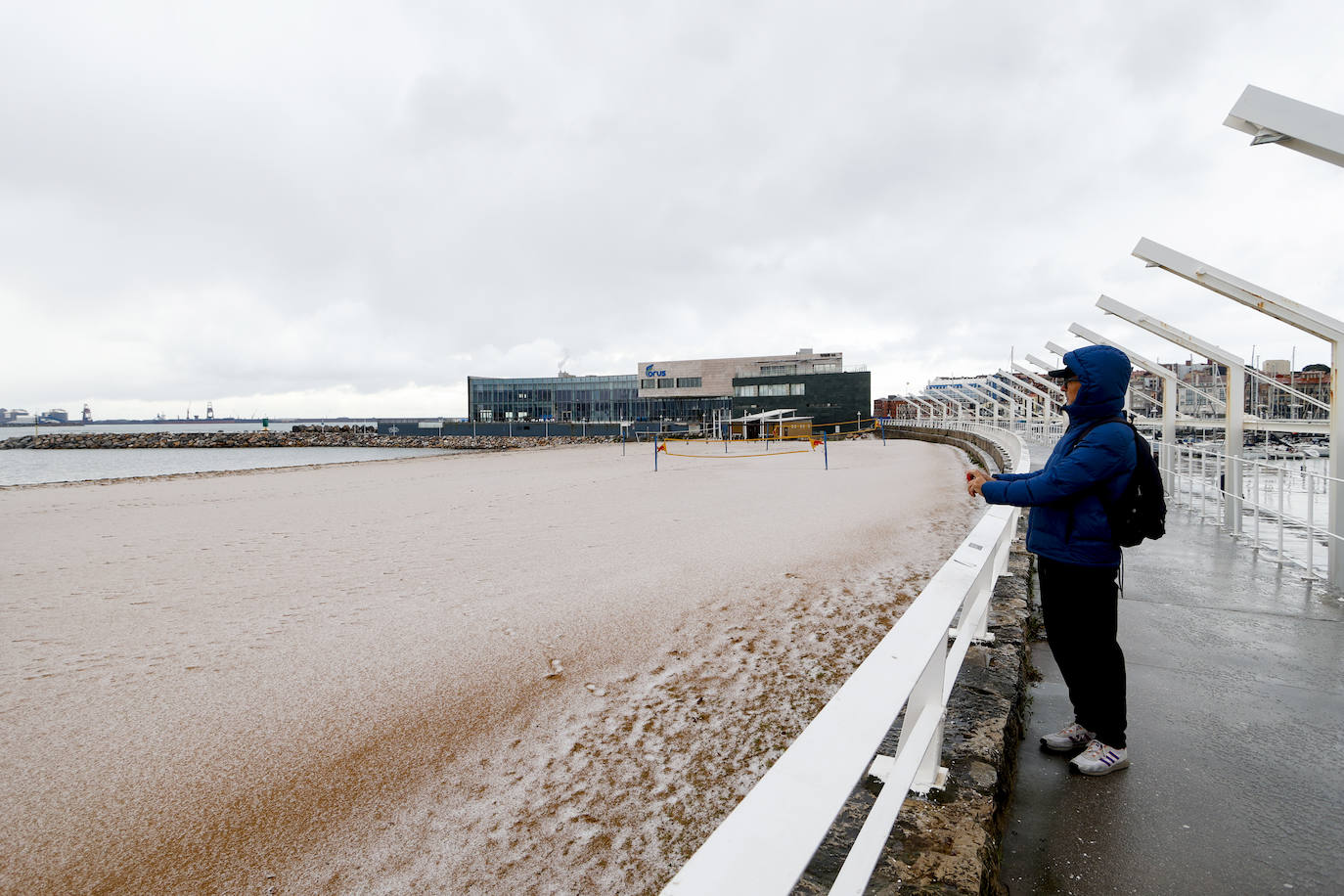 Gijón se abriga bajo la lluvia y el granizo