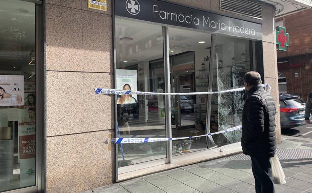 Empotran un coche en el escaparate de una farmacia en Sama y roban la caja registradora