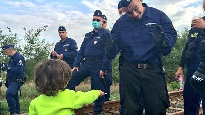 La fotografía de un niño refugiado ofreciendo una galleta a un policía húngaro se convierte en viral