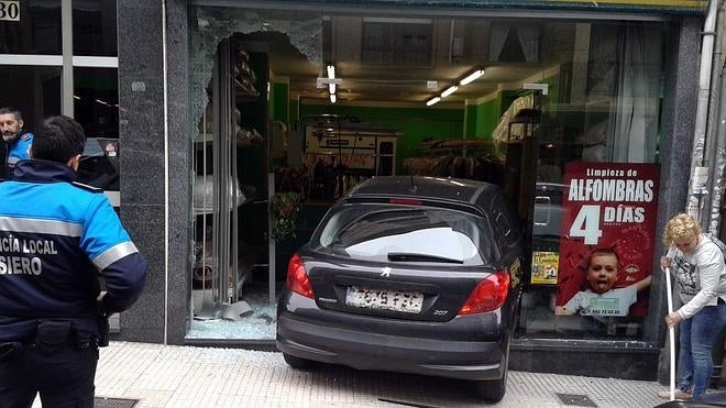 Un coche se empotra en una tintorería de Pola de Siero