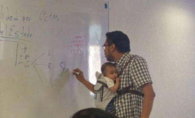 Un profesor carga con el bebé de una alumna en clase para que tome apuntes