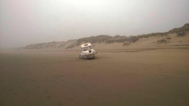 Un barco de recreo vara en medio de la playa de El Espartal